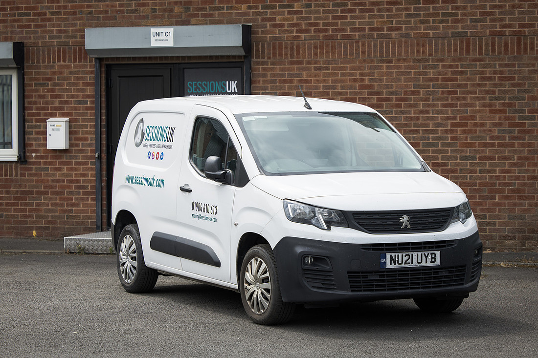 The Sessions UK van parked outside the unit entrance, with the company name above the door.